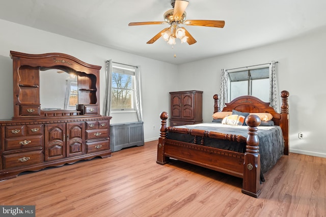 bedroom with radiator heating unit, light hardwood / wood-style floors, and ceiling fan