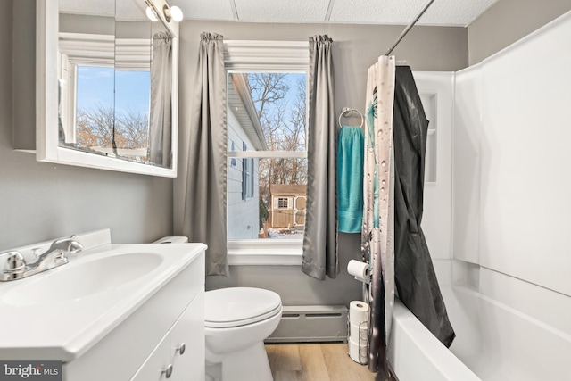 full bathroom featuring a baseboard radiator, plenty of natural light, shower / tub combo with curtain, and vanity