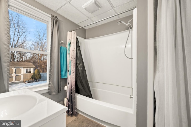 bathroom featuring a drop ceiling and shower / bath combo with shower curtain