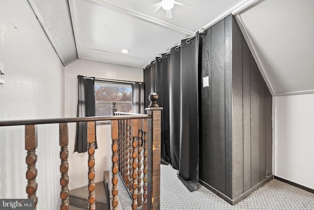 corridor featuring vaulted ceiling and wood walls