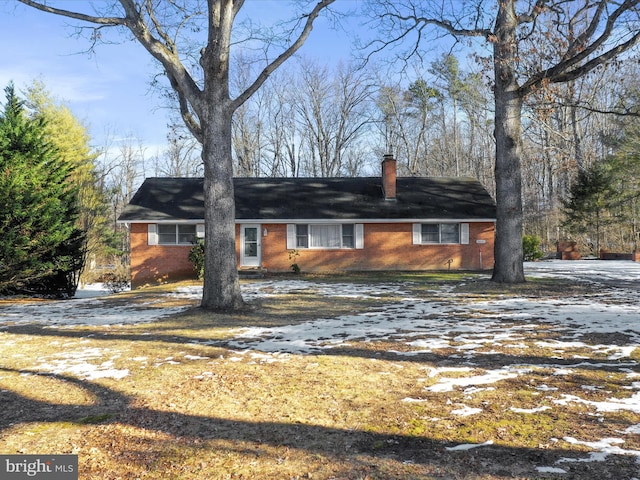 single story home featuring brick siding and a chimney