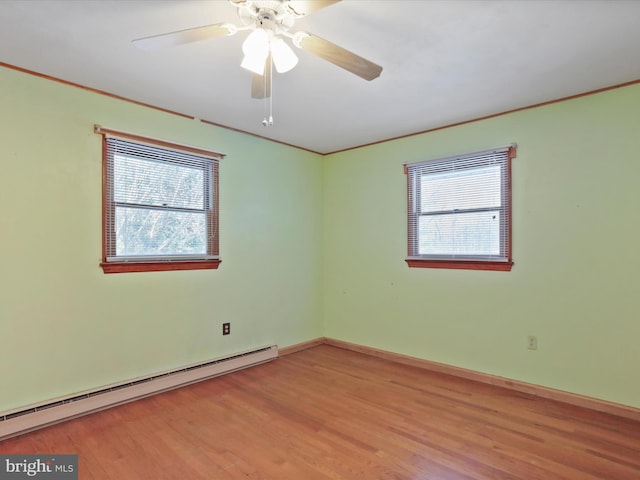 empty room featuring baseboard heating, ceiling fan, ornamental molding, and light hardwood / wood-style flooring