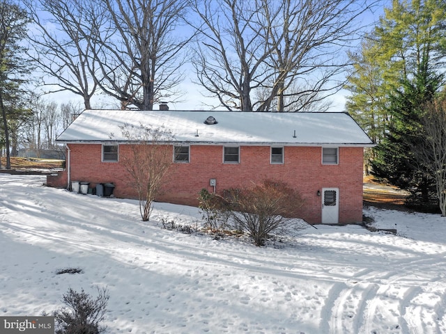 view of snow covered back of property