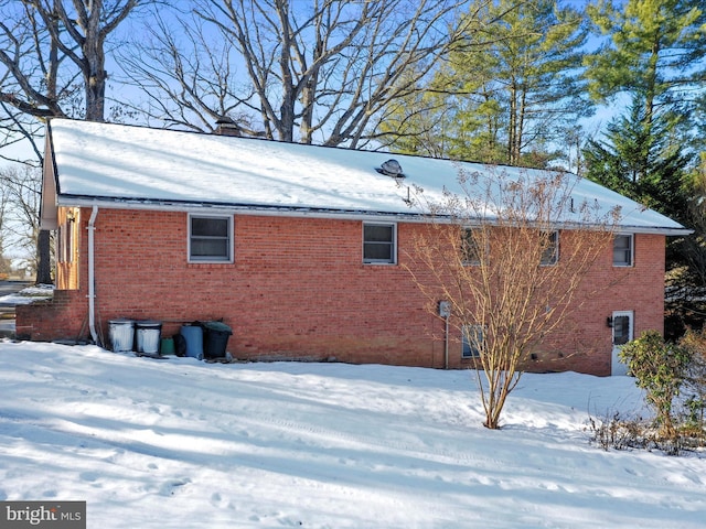 view of snow covered rear of property