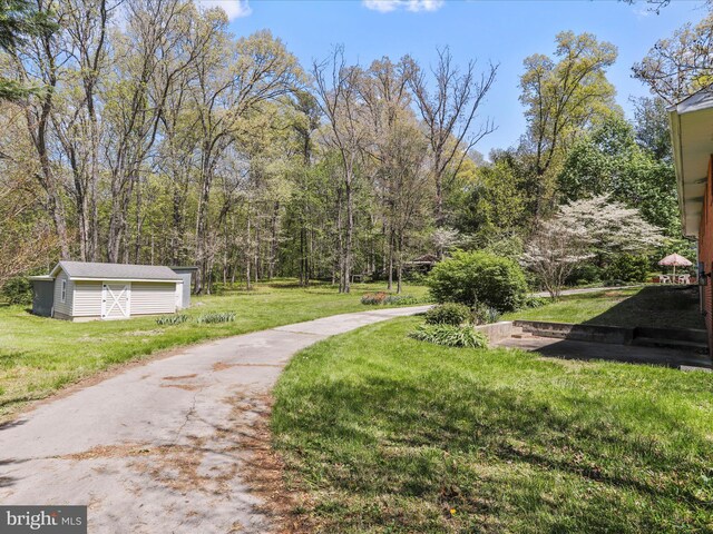 view of home's community featuring a lawn and an outbuilding