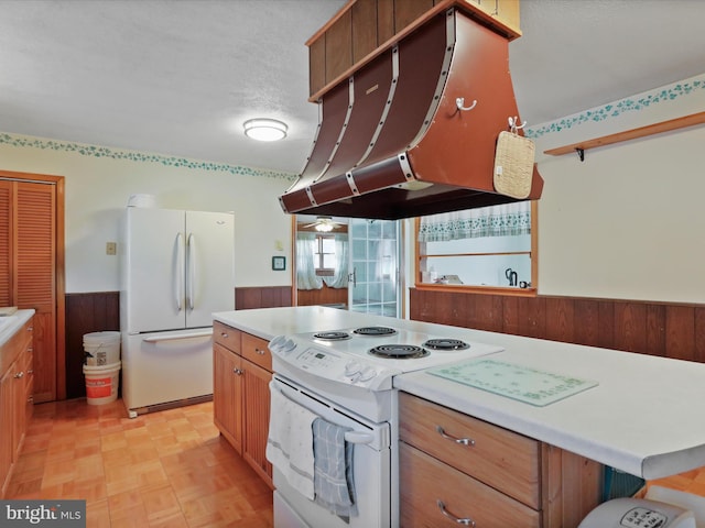 kitchen featuring ventilation hood, a textured ceiling, a kitchen island, white appliances, and light parquet floors