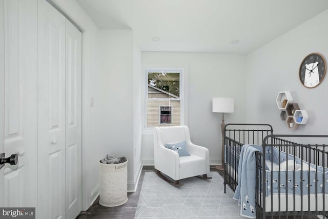 bedroom with hardwood / wood-style floors and a crib