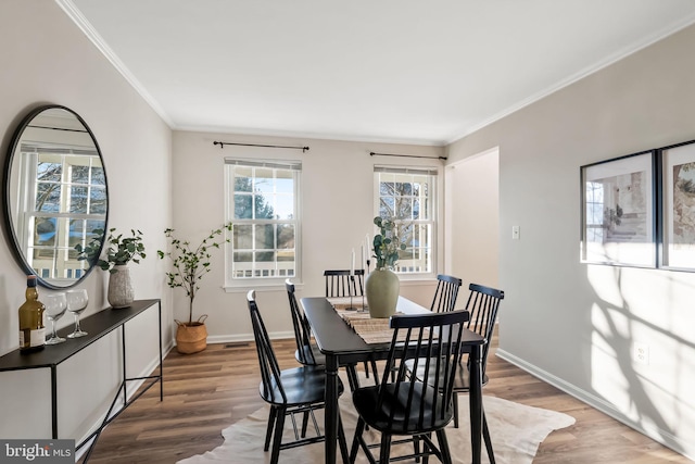 dining space featuring hardwood / wood-style floors and ornamental molding