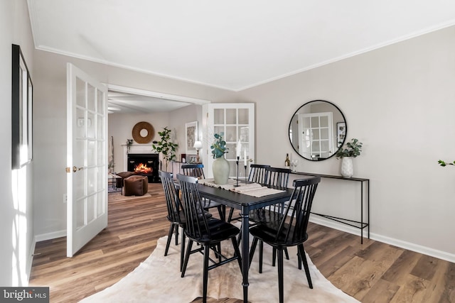 dining space featuring french doors, ornamental molding, and hardwood / wood-style floors