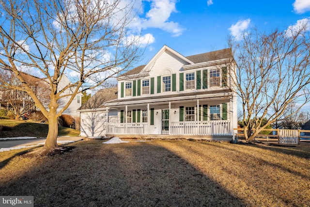 colonial home featuring covered porch and a front lawn