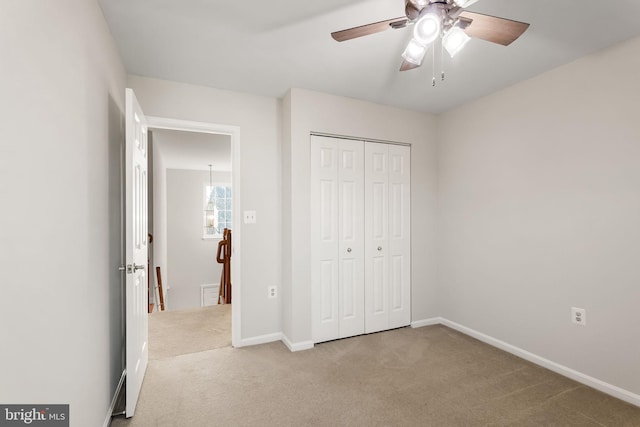 unfurnished bedroom featuring light carpet, ceiling fan, and a closet