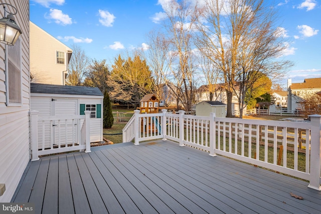 wooden terrace featuring a storage unit and a playground