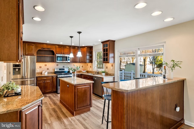 kitchen with sink, a center island, pendant lighting, stainless steel appliances, and backsplash