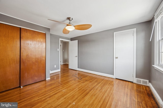 unfurnished bedroom featuring hardwood / wood-style flooring, ceiling fan, and a closet