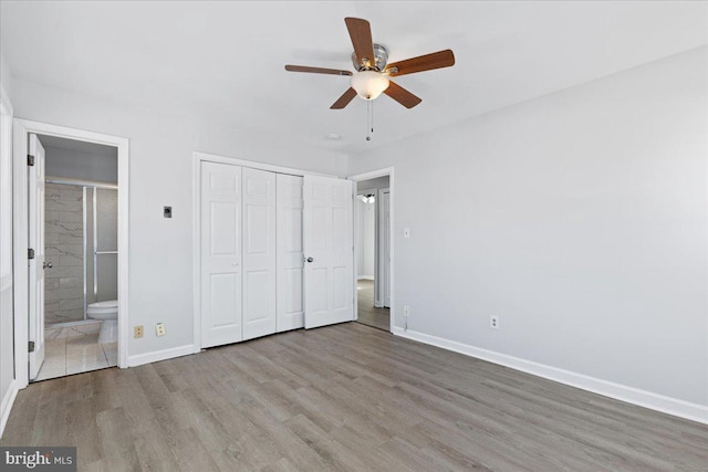 unfurnished bedroom featuring connected bathroom, light hardwood / wood-style flooring, a closet, and ceiling fan