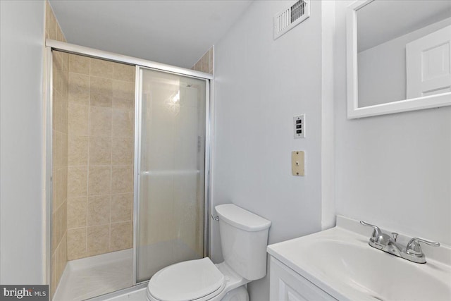 bathroom with vanity, a shower with shower door, and toilet