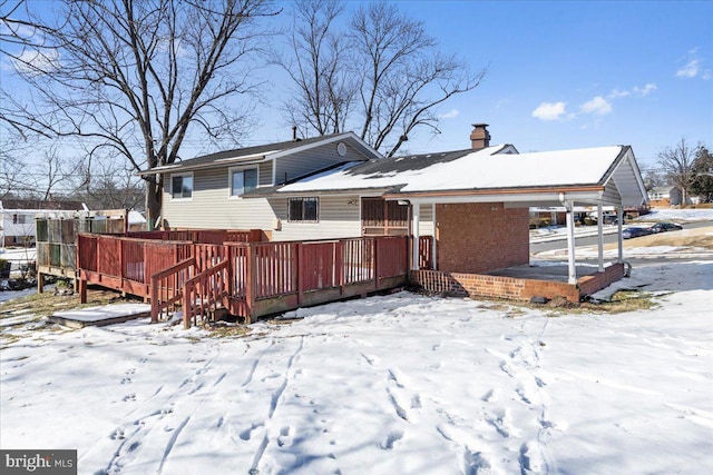 snow covered house with a wooden deck