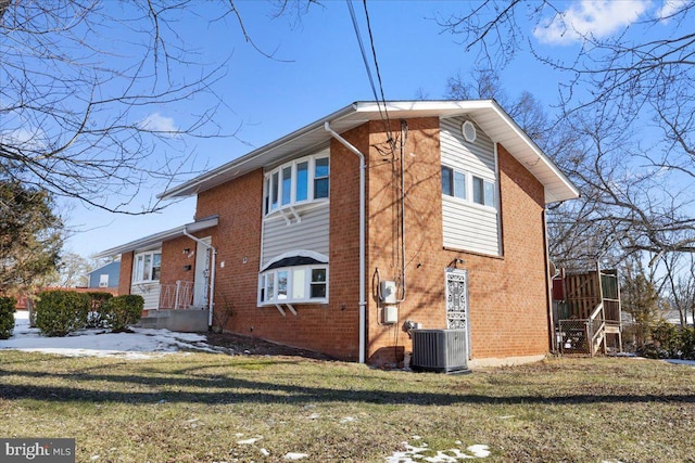 view of home's exterior featuring central AC unit and a lawn