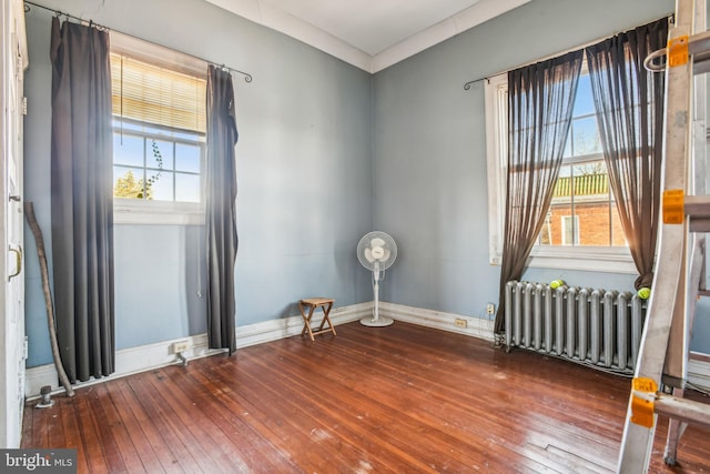 spare room featuring radiator and hardwood / wood-style floors