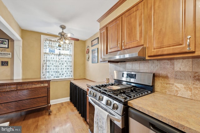 kitchen with decorative backsplash, light wood-type flooring, ceiling fan, and appliances with stainless steel finishes