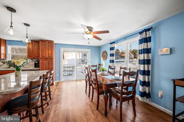 dining area featuring wood-type flooring and ceiling fan