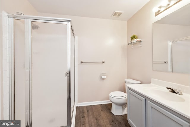 bathroom with hardwood / wood-style flooring, vanity, toilet, and walk in shower