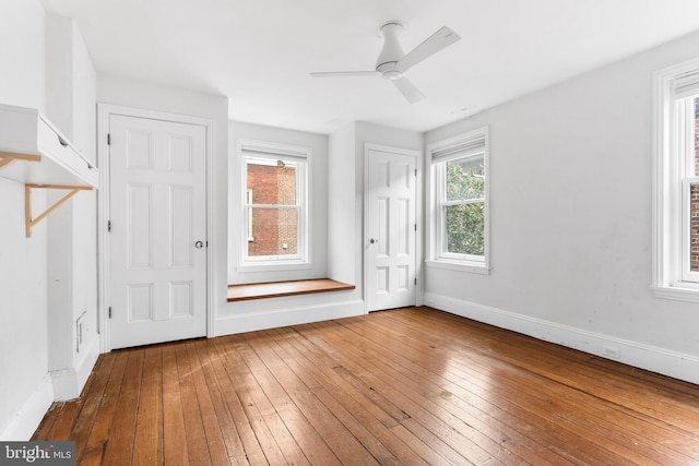 interior space featuring wood-type flooring, ceiling fan, and baseboards