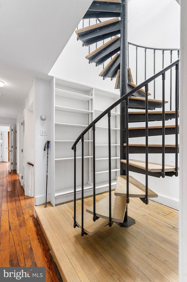 stairway featuring hardwood / wood-style flooring and baseboards