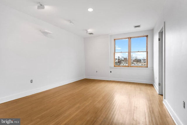 empty room with recessed lighting, baseboards, visible vents, and light wood finished floors