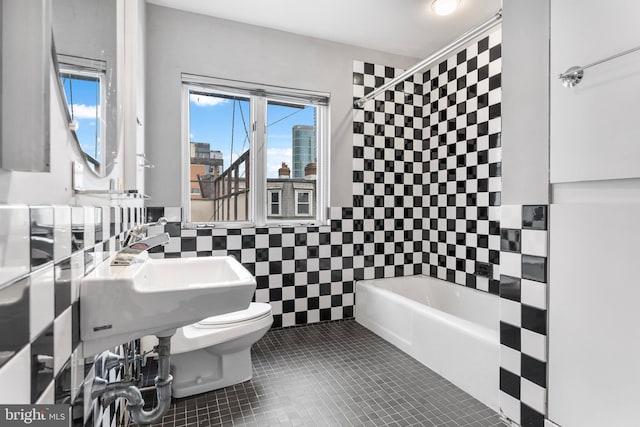 full bathroom with a view of city, tile walls, shower / bath combination, toilet, and tile patterned flooring