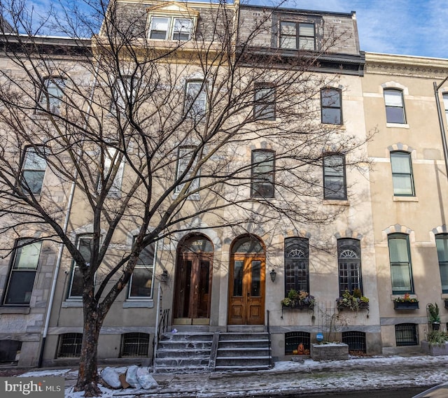 view of front of home featuring entry steps, french doors, and mansard roof