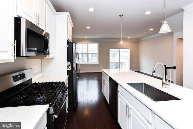 kitchen with hanging light fixtures, sink, white cabinets, and appliances with stainless steel finishes