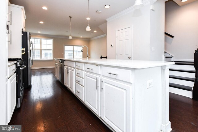 kitchen featuring pendant lighting, dark wood-type flooring, white cabinetry, stainless steel appliances, and an island with sink