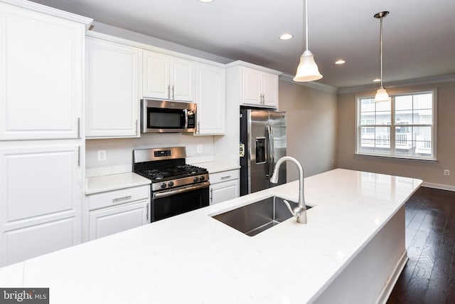 kitchen featuring sink, white cabinetry, hanging light fixtures, stainless steel appliances, and ornamental molding