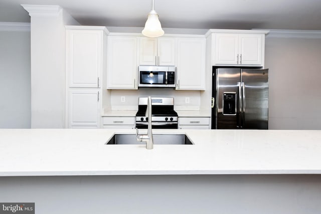 kitchen with white cabinetry, ornamental molding, stainless steel appliances, and pendant lighting