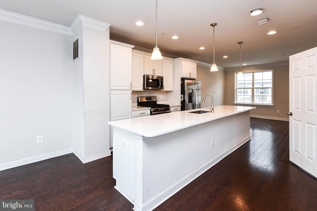 kitchen with appliances with stainless steel finishes, pendant lighting, sink, white cabinets, and a spacious island