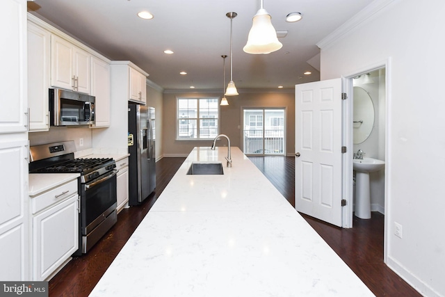 kitchen with sink, white cabinetry, hanging light fixtures, stainless steel appliances, and light stone countertops