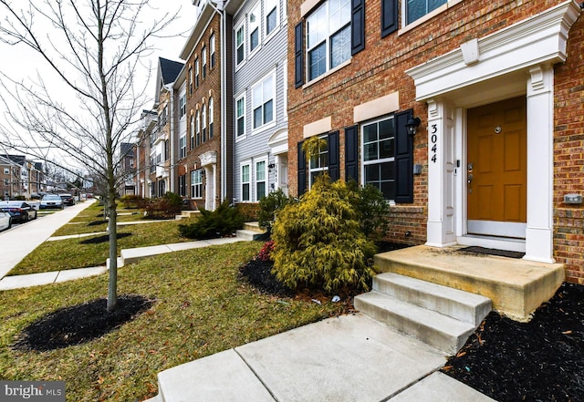 property entrance with a lawn