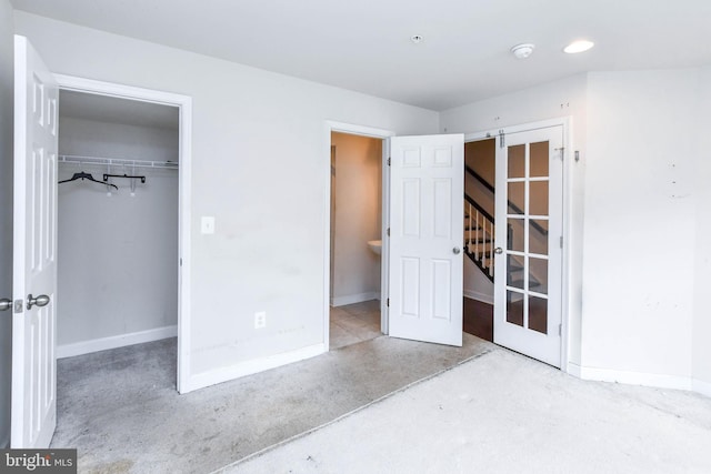 unfurnished bedroom featuring a barn door, a walk in closet, and a closet