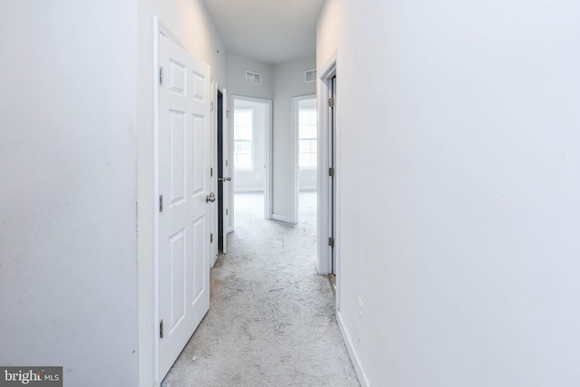 hall featuring light colored carpet