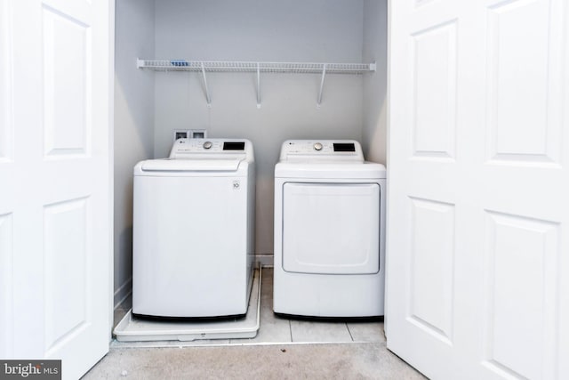 laundry area with light tile patterned flooring and separate washer and dryer