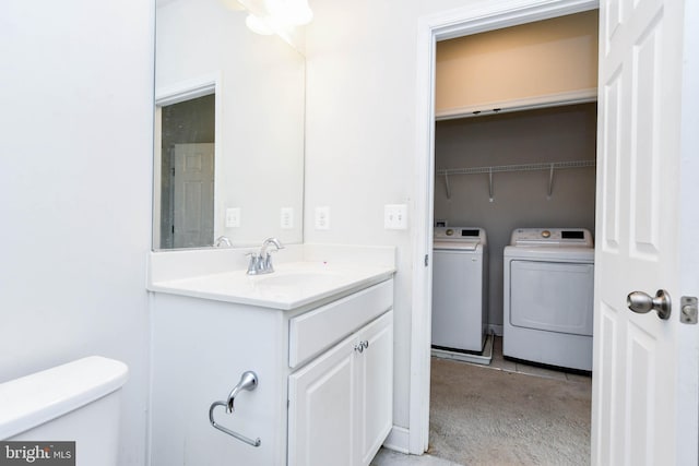 bathroom with vanity, washer and dryer, and toilet