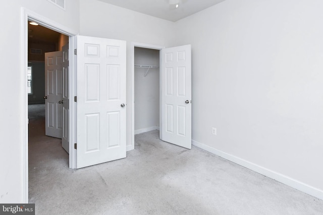 unfurnished bedroom featuring light carpet and a closet