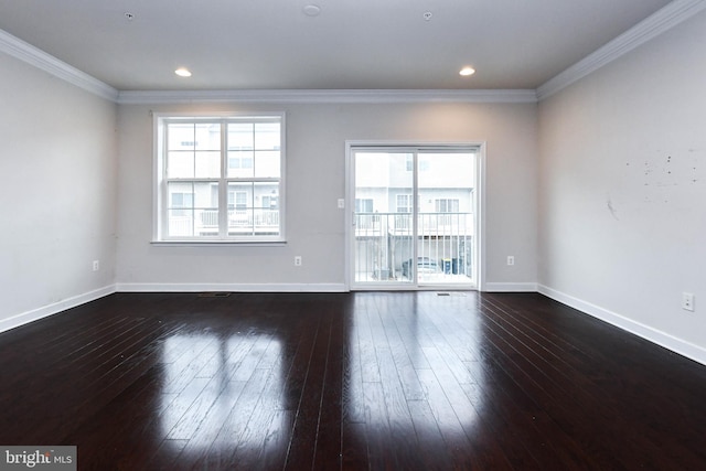 spare room with ornamental molding and dark hardwood / wood-style floors