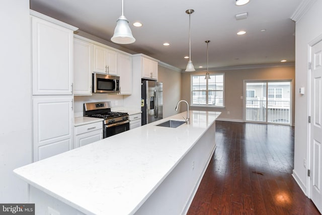 kitchen featuring white cabinetry, stainless steel appliances, decorative light fixtures, and sink