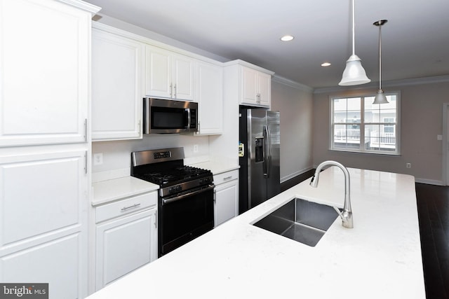 kitchen featuring decorative light fixtures, white cabinetry, sink, ornamental molding, and stainless steel appliances