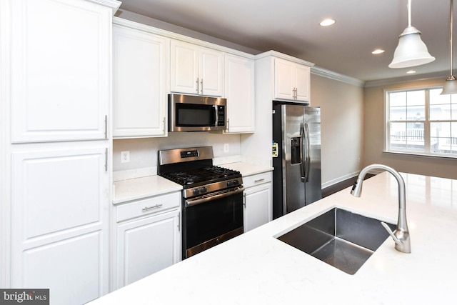 kitchen with sink, crown molding, decorative light fixtures, stainless steel appliances, and white cabinets