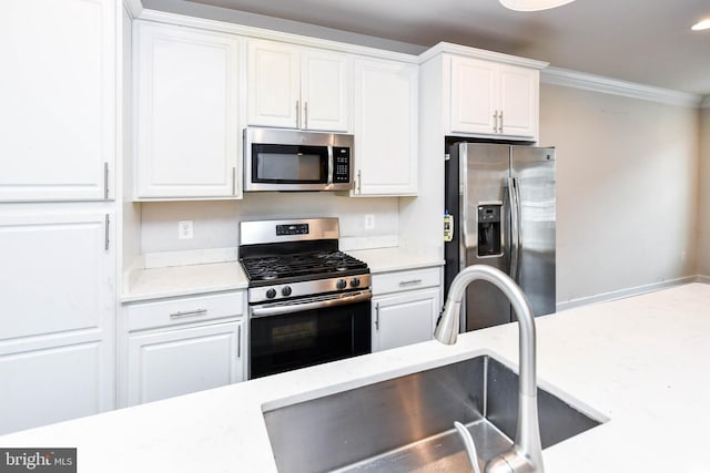 kitchen with white cabinetry, appliances with stainless steel finishes, sink, and ornamental molding