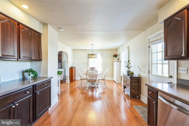 kitchen featuring dark brown cabinetry, pendant lighting, stainless steel dishwasher, and light wood-type flooring