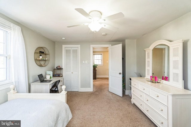 bedroom featuring light carpet, a closet, and ceiling fan